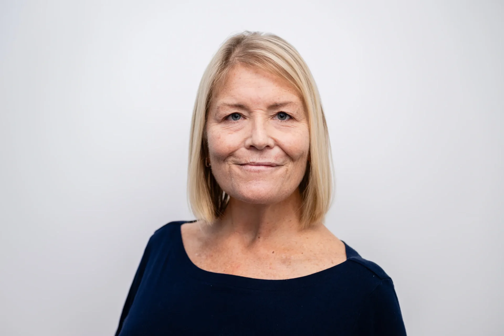 A woman with blonde hair and wearing a black shirt.